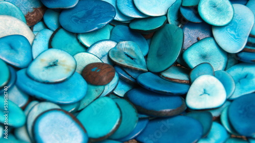 Pile of polished, sliced tagua nuts, dyed blue, at a tagua nut jewelry shop in Iluman, Ecuador photo