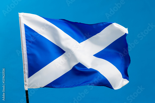 Scottish flag waving on blue background photo