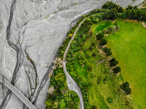 An aerial image of a green agricultural paddock on the shore of a river on the South Island of New Zealand