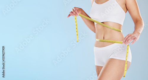 Tape measure, stomach and woman health diet, fitness and detox weight goals, target and abdomen on mockup blue background. Liposuction, tummy tuck and wellness model, bmi progress and skinny body fat photo