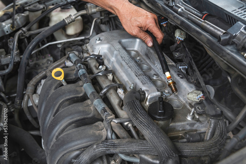 Auto mechanic checking spark plugs from the old motor. photo