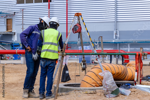 The safety officer and Engineering team discuss working method before sending workers into a confined space.