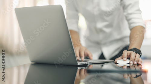 Closeup man hands using mouse and laptop computer.