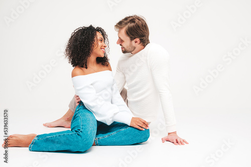 Smiling beautiful woman and her handsome boyfriend. Happy cheerful multiracial family having tender moments on grey background in studio. Multiethnic models hugging. Embracing each other.Love concept