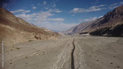 Bird's eye view of a car parked on a road between mountains in Ladakh, India photo