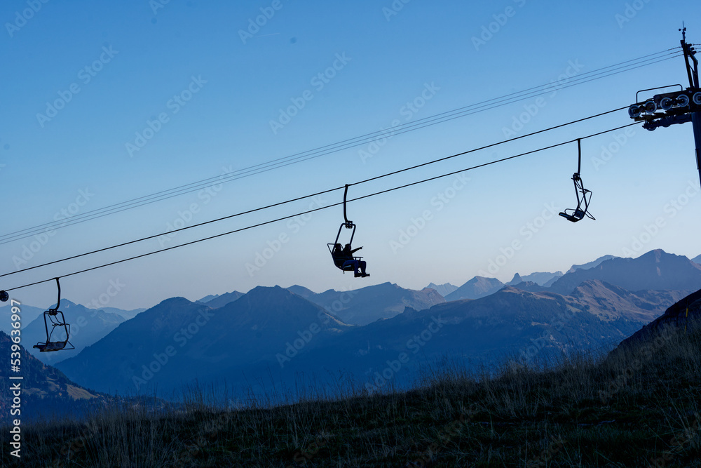 Chair lift at ski resort Axalp with tourists going up on a beautiful autumn morning view view over the Swiss Alps on a sunny autumn day. Photo taken October 18th, 2022, Axalp, Switzerland.