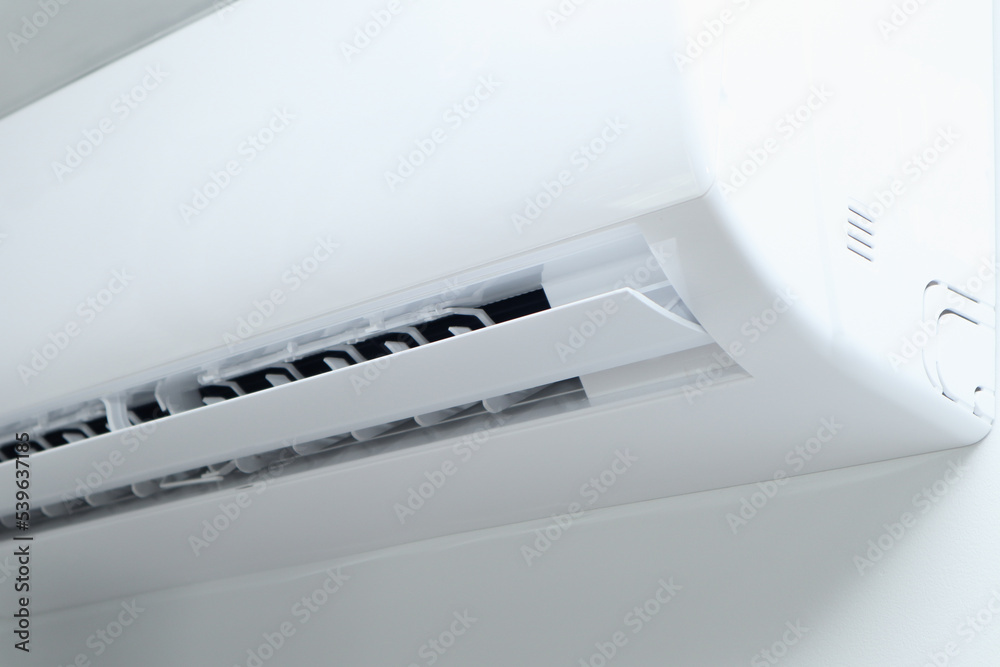 Air conditioner on white wall background. Split air conditioner on a white wall. Closeup image. Air conditioner on white wall background. Split air conditioner on a white wall. Closeup image.