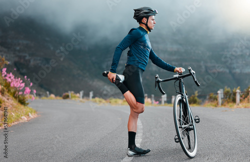 Fototapeta Naklejka Na Ścianę i Meble -  Sports, fitness and man stretching in a road during cycling workout, training and focus in nature. Bike, sport and performance preparation by athletic cyclist doing leg stretch before exercise
