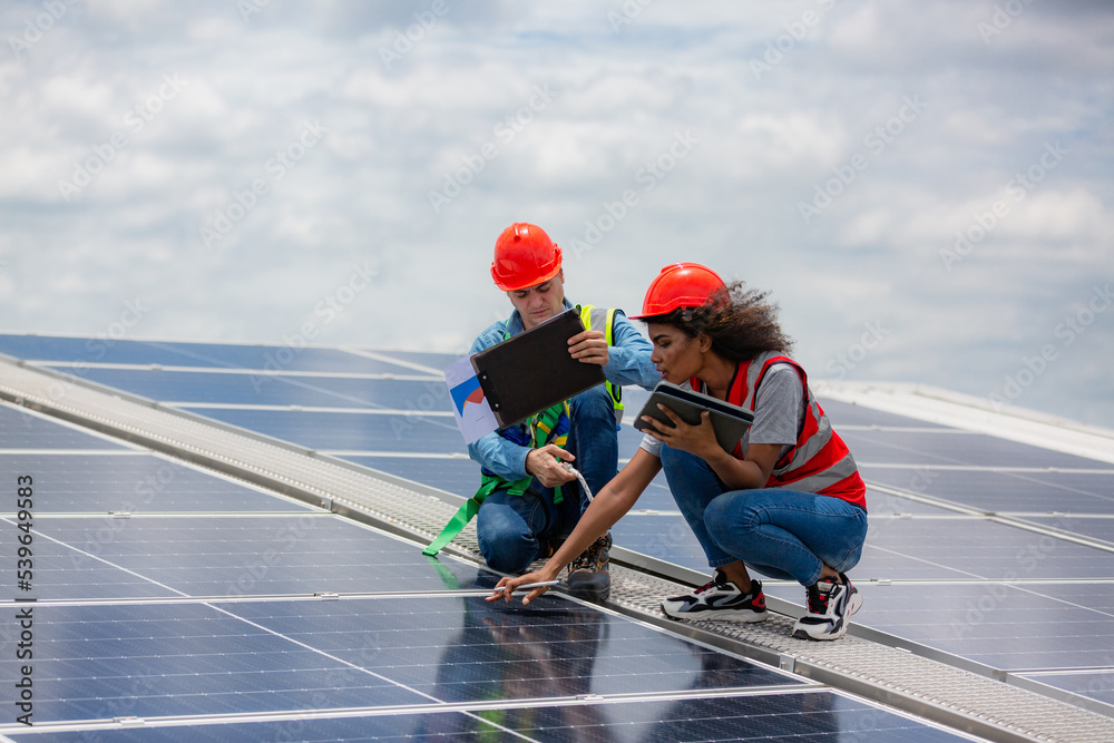technician engineer working on checking maintenance service with solar batteries near solar panels at sunny day in solar power plant station on rooftop, electricity energy of photovoltaic industrial technician engineer working on checking maintenance service with solar batteries near solar panels at sunny day in solar power plant station on rooftop, electricity energy of photovoltaic industrial