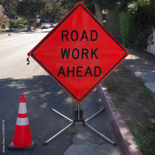 ROAD WORK AHEAD road sign and traffic cone
