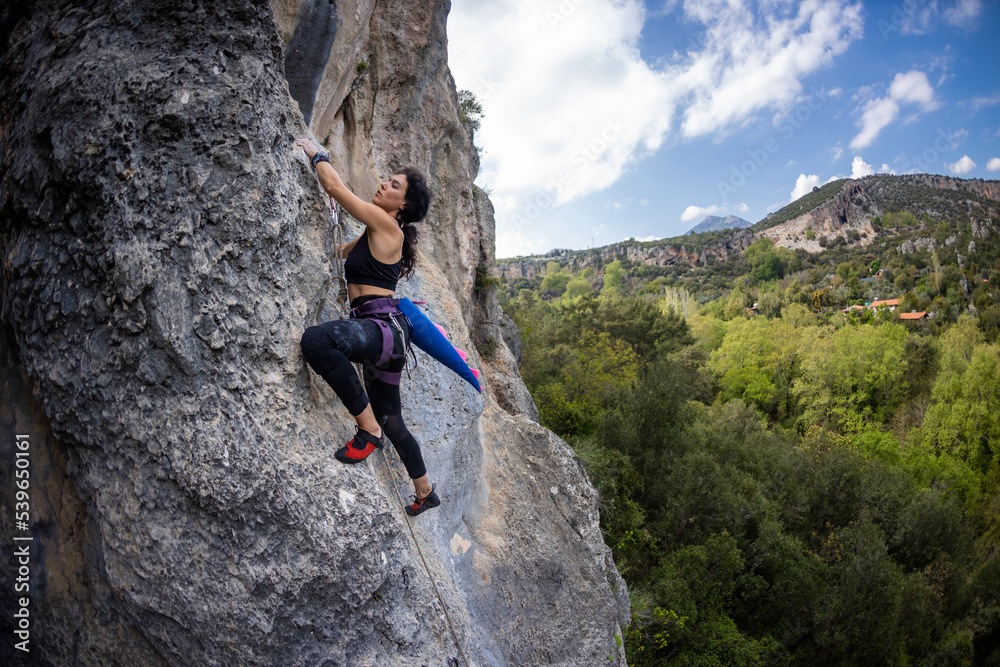 Rock climber girl climbing a rock with a dinosaur tail