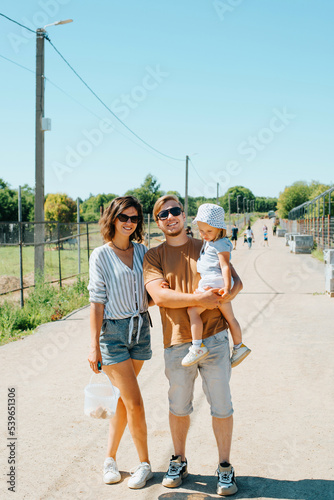 Family portrait in full length. Happy mom, dad and little daughter in the countryside © Sergio