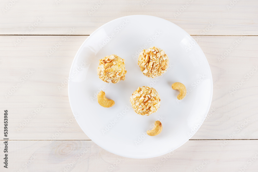 Traditional brazilian brigadeiro sweets with cashew nuts on a wooden table. Top view, flat lay. Traditional brazilian brigadeiro sweets with cashew nuts on a wooden table. Top view, flat lay.