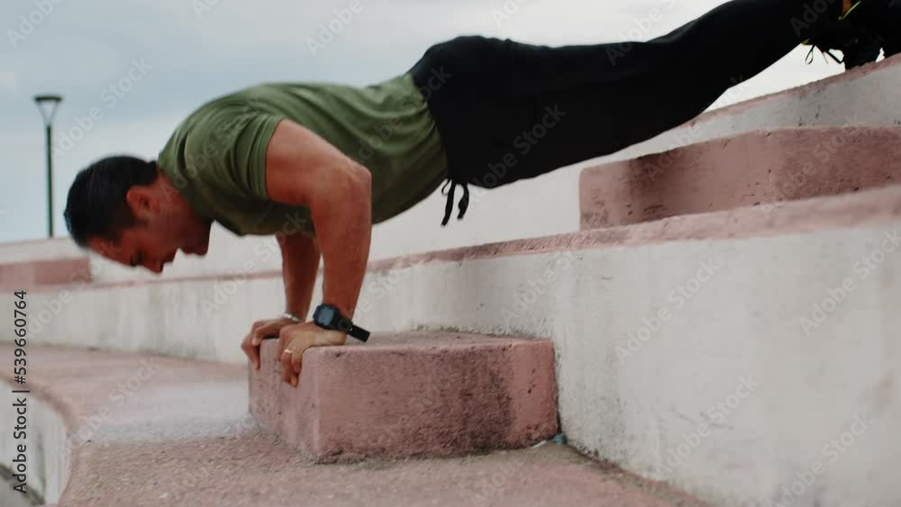 Boy in green t-shirt making push up exercise sport outdoor after rainy day