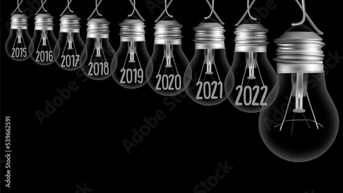Shining light bulb with New Year 2023 and group of dark light bulbs in a row going from 2015 to 2022 isolated on black background. High quality 4k video.