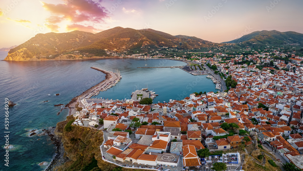 Fototapeta premium Aerial view of the town of Skopelos island with the traditional, red roofed houses during a calm summer sunset, Sporades, Greece