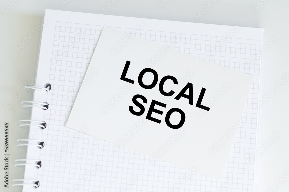 Office table withnotepad and white card with text LOCAL SEO. Top view, flat lay. Stylish workplace Office table withnotepad and white card with text LOCAL SEO. Top view, flat lay. Stylish workplace