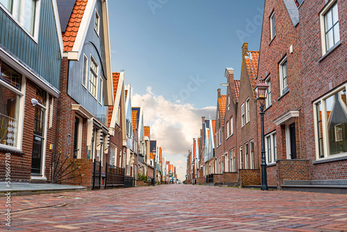 Fotografiet low angle view of cobbled street and typical buildings in dutch town of Volendam