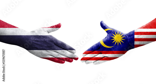 Handshake between Malaysia and Thailand flags painted on hands, isolated transparent image.