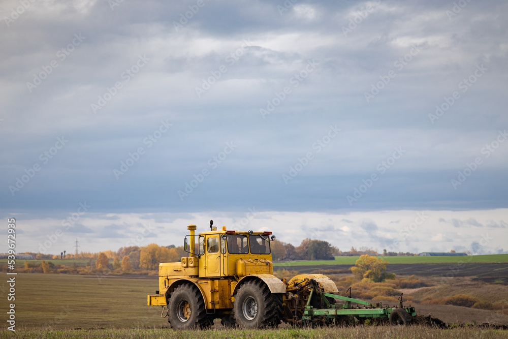old model tractor working in the field. old model tractor working in the field.
