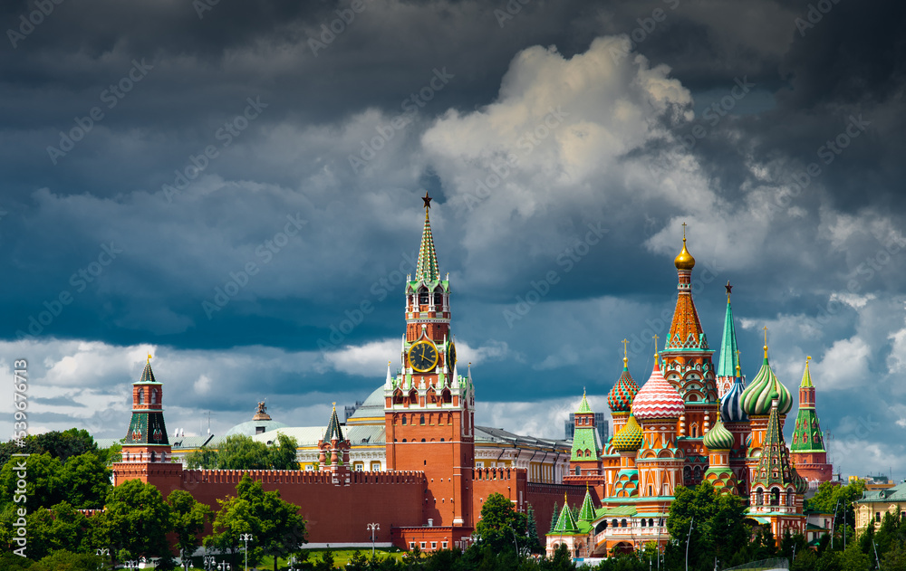Spasskaya Tower of Moscow Kremlin and Cathedral of Vasily the Blessed (Saint Basil's Cathedral) on Red Square in summer day. Black clouds before the rain. Panorama. Moscow. Russia Spasskaya Tower of Moscow Kremlin and Cathedral of Vasily the Blessed (Saint Basil's Cathedral) on Red Square in summer day. Black clouds before the rain. Panorama. Moscow. Russia