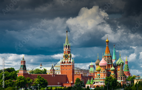 Spasskaya Tower of Moscow Kremlin and Cathedral of Vasily the Blessed (Saint Basil's Cathedral) on Red Square in summer day. Black clouds before the rain. Panorama. Moscow. Russia