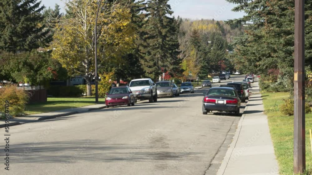Pan to the right of the empty Calgary road with parked cars Pan to the right of the empty Calgary road with parked cars