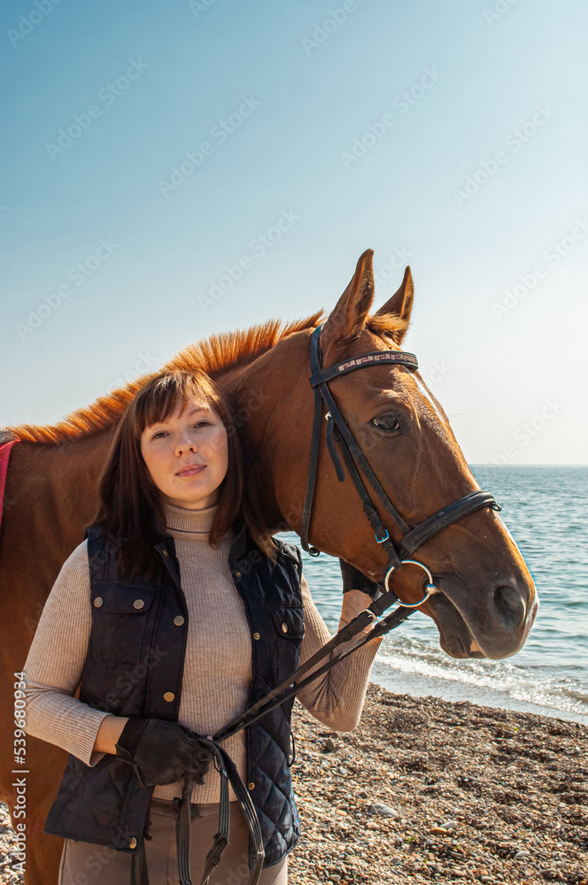 Obraz premium Selective focus. Girl and horse. Horse riding by the sea.