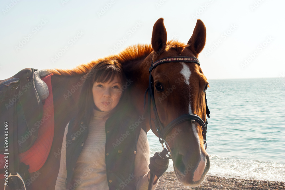 Obraz premium Selective focus. Girl and horse. Horse riding by the sea.