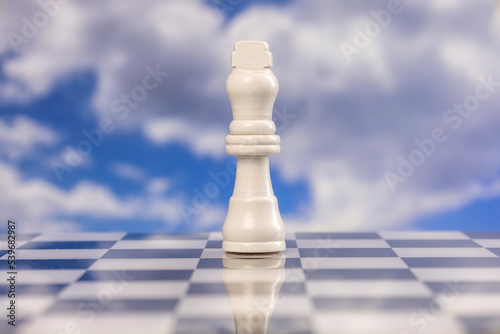 Chess king piece with passing clouds behind