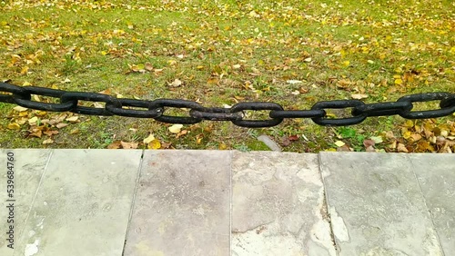 old black chain moves against the background of autumn foliage in the park
