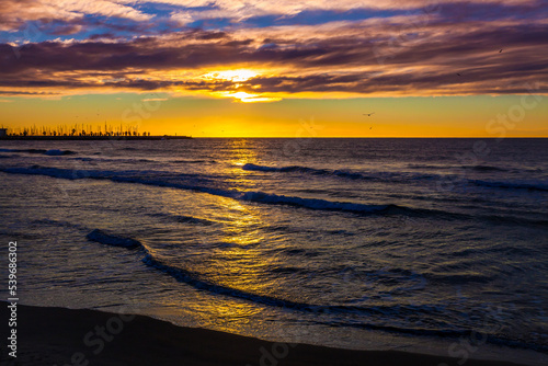 Incredibly beautiful best orange sunrise on the Mediterranean Sea in Sitges. Sea  sky with clouds  birds and horizon
