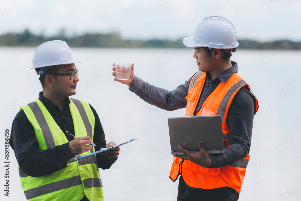 Fototapeta premium Environmental engineers work at wastewater treatment plants,Water supply engineering working at Water recycling plant for reuse,Technicians and engineers discuss work together.