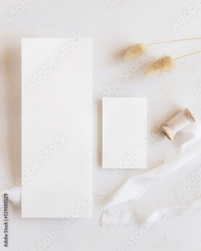 Blank cards near silk ribbons and dried hare's tail grass top view on white, boho mockup