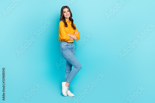 Full body profile photo of positive satisfied lady crossed arms empty space isolated on blue color background