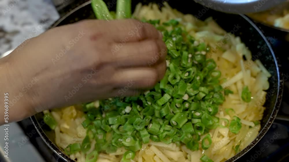 Adding Chopped Green Beans To Saucepan On Top Of Sliced Potatoes And Onions Adding Chopped Green Beans To Saucepan On Top Of Sliced Potatoes And Onions