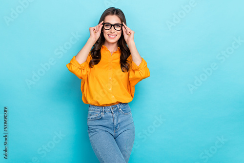 Photo of positive nice girl hands touch eyeglasses beaming smile isolated on blue color background