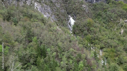 Waterfall cascading though trees Lake Bohinj Slovenia drone aerial view photo