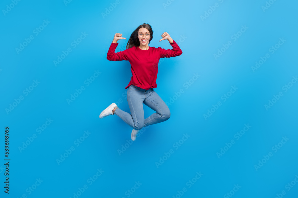 Full body photo of hooray millennial lady jump index herself wear eyewear shirt jeans shoes isolated on blue background