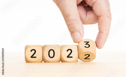 Hand changing Wooden Blocks with 2022 to 2023 year. Copy space