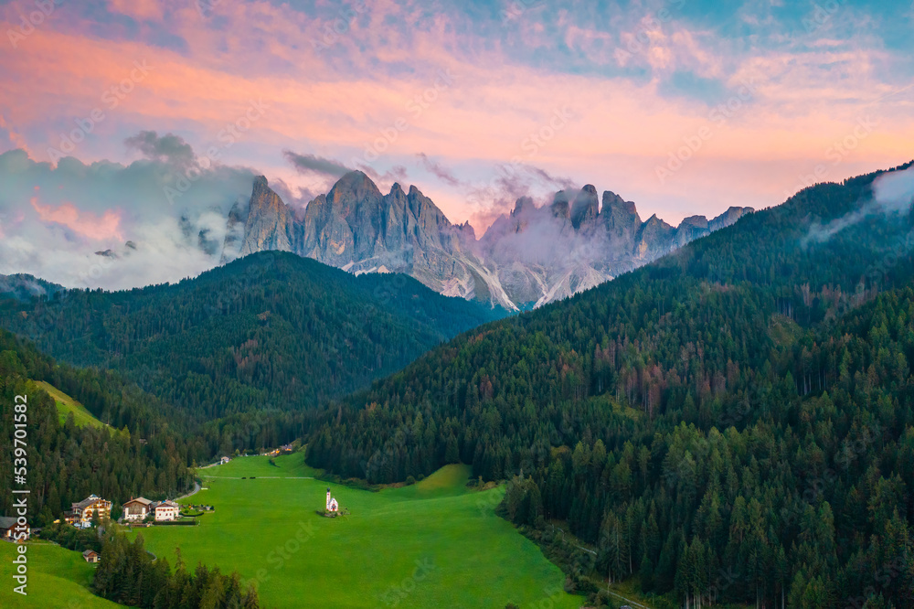 Scenic landscape from Santa Maddalena valley with Olde peaks of the Dolomites with magic pink sunset. 