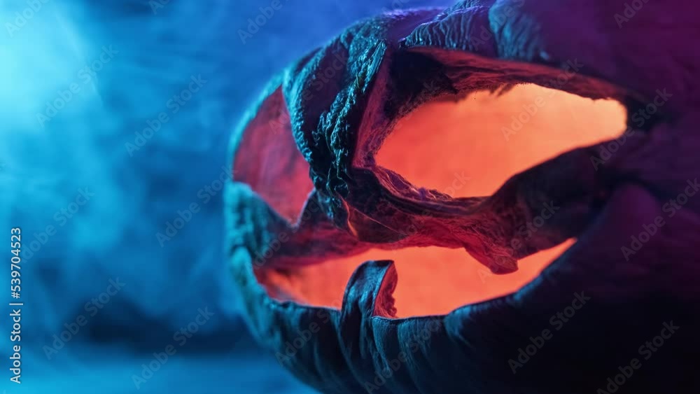 Halloween aged pumpkin smile and scary eyes with smoke at dark