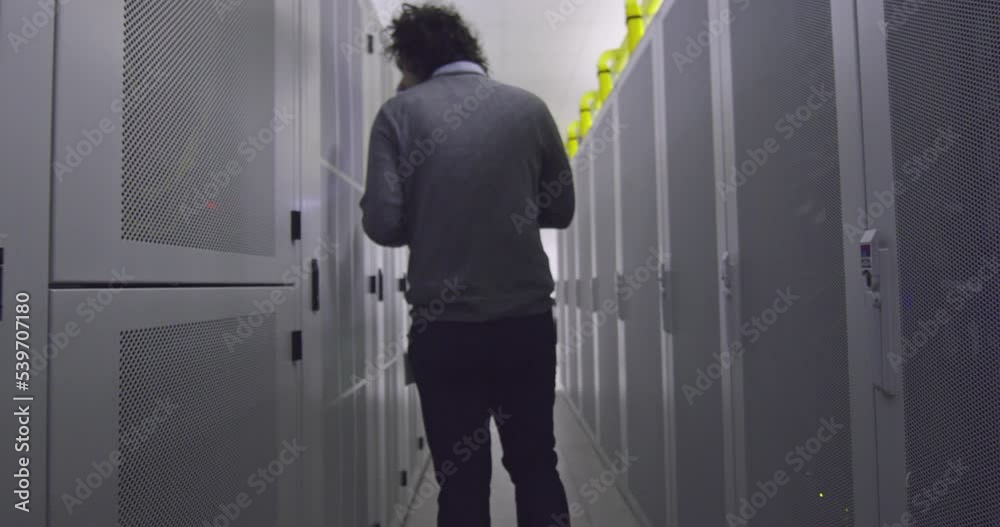 IT engineer or data science specialist working on tablet computer in server room at a modern cloud computing virtual data center supercomputer. IT engineer or data science specialist working on tablet computer in server room at a modern cloud computing virtual data center supercomputer.