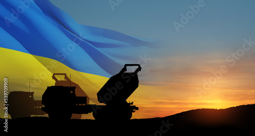 Artillery rocket system are aimed to the sky at sunset with Ukrainian flag. Multiple launch rocket system. 3d-rendering. © hamara