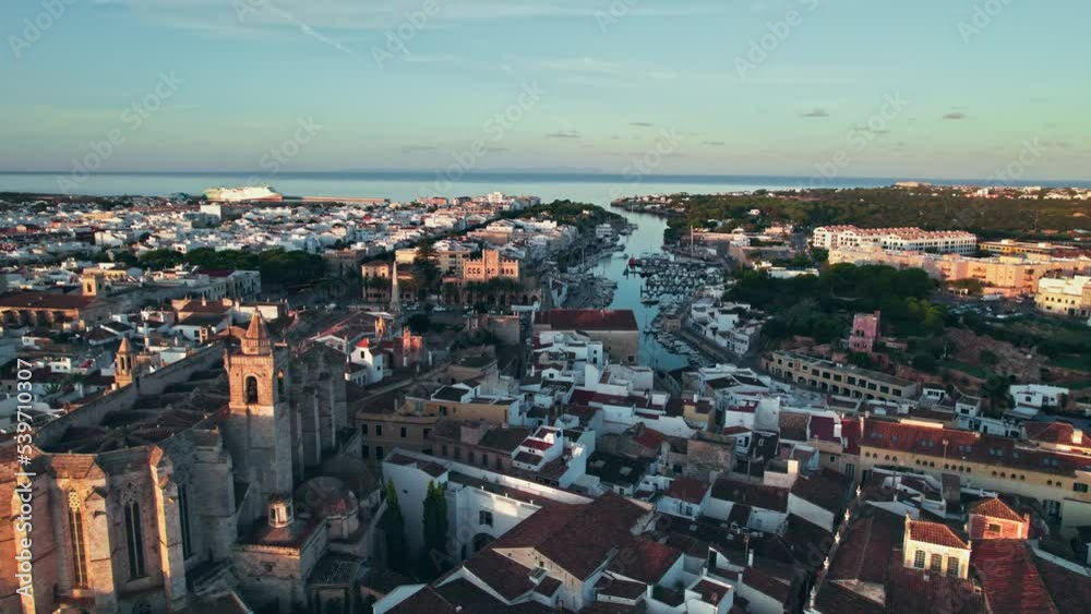 Beautiful sunset over Ciutadella de Menorca and Catedral de Santa Maria, Spain. Aerial panoramic view of the touristic Spanish Balearic Islands with traditional houses and buildings by coastal beaches