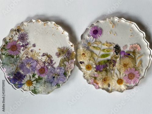 Decorative cup glass handmade coasters made of transparent epoxy resin with dry flowers on a white table photo