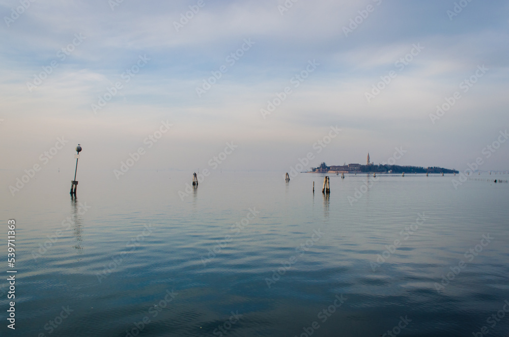 L'isola di Poveglia vista dal Lido di Venezia in una giornata nuvolosa