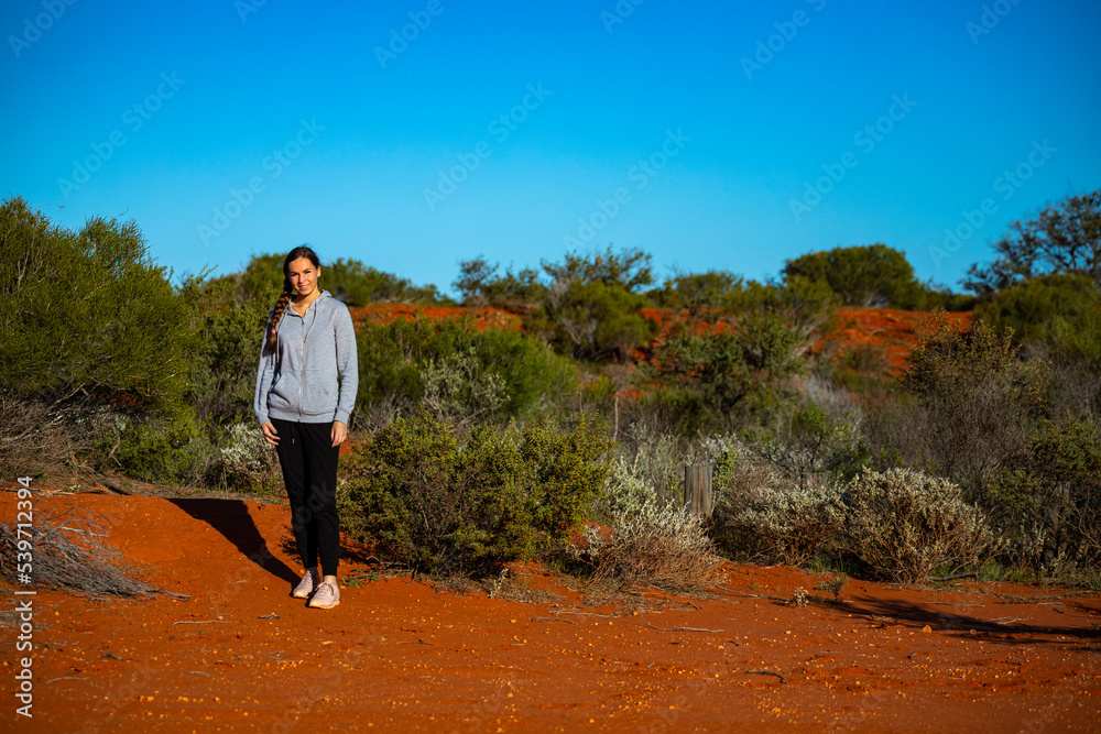 long-haired girl hiking in australian red sand desert; terra rosa in francois peron national park, shark bay, western australia long-haired girl hiking in australian red sand desert; terra rosa in francois peron national park, shark bay, western australia