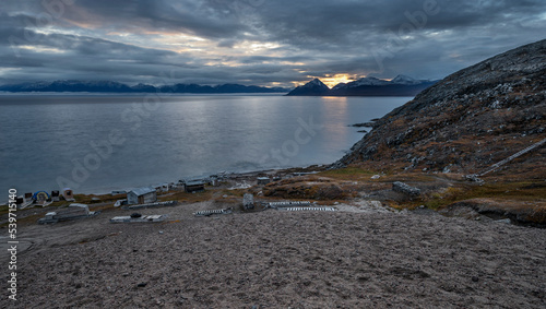 The Arctic Ocean and the Byam Martin Mountains with sleds and huts on the coast of Baffin Island photo