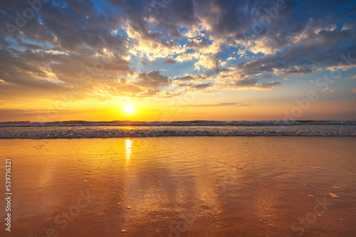 Beautiful sunrise over the sea waves and beach